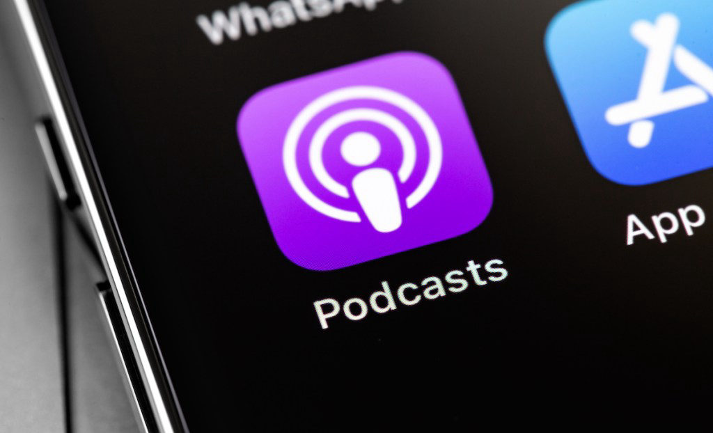 Icono de Apple Podcasts en la pantalla de un teléfono, relacionado con la estrategia de Apple para desarrollar experiencias de audio personalizado mediante inteligencia artificial.